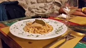 a plate of food on a table with wine glasses at Residenza d'Epoca Borgodifiume in Fiumefreddo Bruzio