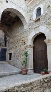 a building with a door with a plant in front of it at Residenza d'Epoca Borgodifiume in Fiumefreddo Bruzio