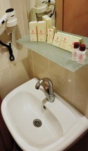 a white sink in a bathroom with a mirror at Grand Zeybek Hotel in İzmir