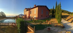 une grande maison avec un étang en face de celle-ci dans l'établissement Agriturismo Rimaggiori relaxing country home, à Barberino di Mugello