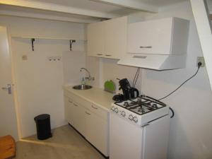 a small kitchen with a stove and a sink at Holiday Home Emmastraat in Katwijk