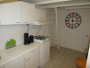 a kitchen with a stove and a clock on the wall at Holiday Home Emmastraat in Katwijk