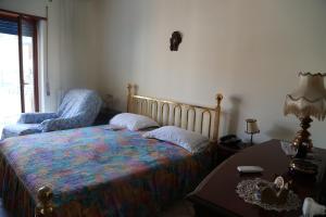 ナポリにあるStanza in appartamentoのベッドルーム1室(ベッド1台、椅子、テーブル付)