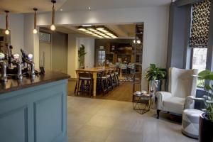 a room with a bar and a table and chairs at Best Western Plus Nottingham Westminster Hotel in Nottingham
