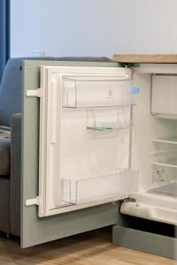 an empty refrigerator with its door open at 9010 Apartments in Vilnius