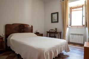 a bedroom with a white bed in a room with a window at Hostal Puerta Medina in Sigüenza