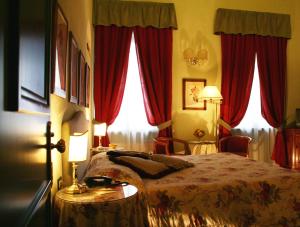 a hotel room with a bed and red curtains at JOIVY Together Florence Secret Nest in Florence