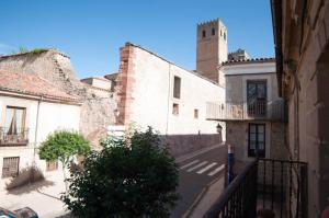 an alley in an old building with a tower at Hostal Puerta Medina in Sigüenza