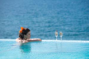 パノルモス・レティムノにあるThalassa Residence, a luxury coastal escape, By ThinkVillaのシャンパングラス2杯付きスイミングプールの女性