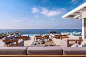 パノルモス・レティムノにあるThalassa Residence, a luxury coastal escape, By ThinkVillaの海の景色を望むパティオ(ソファ付)