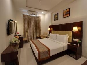 Habitación de hotel con cama y sala de estar. en Hotel Sai Jashan, en Shirdi