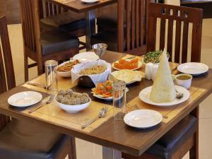 a wooden table with plates of food on it at Hotel Sai Jashan Shirdi - Where blessings & comfort meet in Shirdi