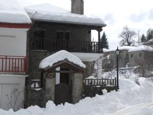 una casa cubierta de nieve con techo en Guesthouse Ariadni en Kríkellon