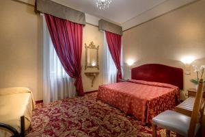 a hotel room with a red bed and a window at Hotel San Marco Sestola in Sestola