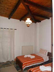 1 dormitorio con 2 camas y lámpara de araña en Guesthouse Ariadni, en Kríkellon