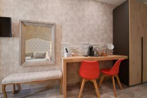 ローマにあるルレ バルベリーニの鏡付きの洗面台と椅子2脚が備わる客室です。
