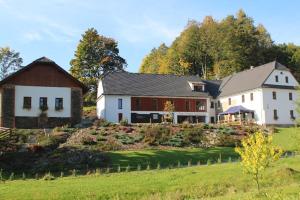 a large white house and a barn on a field at Relax pension Schonwald in Budišov nad Budišovkou