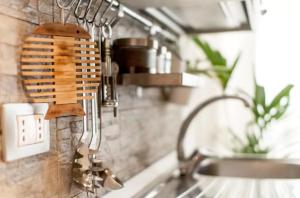 a kitchen sink with a kitchen utensils on a wall at Casa Vacanze Parco Archeologico in Siracusa