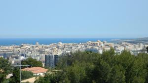 a city with buildings and the ocean in the background at Casa Vacanze Parco Archeologico in Siracusa