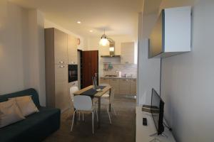 ein Wohnzimmer mit einem Tisch und einem Sofa sowie eine Küche in der Unterkunft Appartamento Zona Torregalli_Nuvola Rossa in Florenz