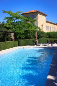 une grande piscine en face d'un bâtiment dans l'établissement Gite des Carmes and Spa, au Thor