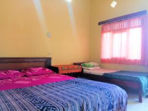 a bedroom with two beds and a window at Arjuna Homestay Ubud in Ubud
