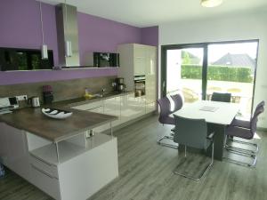 eine Küche mit lilafarbenen Wänden sowie einem Tisch und Stühlen in der Unterkunft Kleeblatthaus WG flieder in Putbus