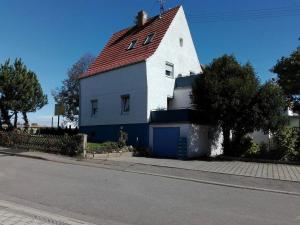 a white house with a red roof on a street at Gästezimmer Fuchs in Neuhausen auf den Fildern