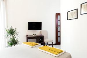 a bedroom with a bed with a desk and a television at B&B Cozy Cove in Torre del Greco