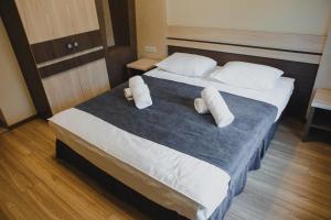 1 dormitorio con 1 cama grande y 2 almohadas en Hotel Merry Land, en Horodenka