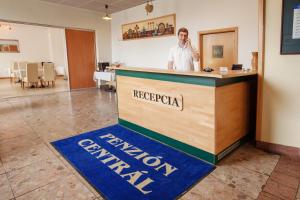 a man is standing at a reception counter at Penzión Centrál in Zvolen