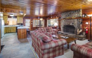 a living room with couches and a stone fireplace at 55 Deer Creek in Wawona
