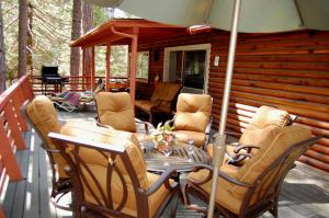 a deck with a table and chairs on a cabin at 39 River Song in North Wawona