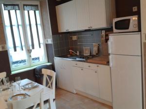 a kitchen with a white refrigerator and a table at A la Terrasse coeur Honfleur in Honfleur