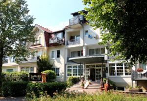 ein großes weißes Gebäude mit einer Treppe davor in der Unterkunft Parkhotel Weber-Müller in Bad Lauterberg
