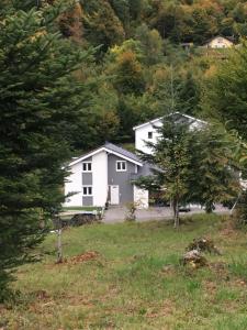 a house in a field with trees in the background at Chambre Zen Et Calme in Bouveret
