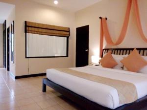 a bedroom with a large bed and a window at Sudala Beach Resort in Khao Lak