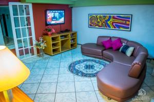 a living room with a couch and a tv at Hotel Casa Grande Itapira in Itapira