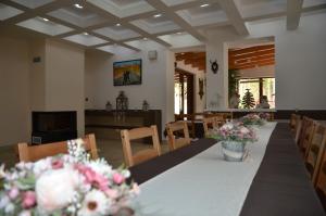 a dining room with a table with flowers on it at Chata Patúch in Babkov