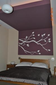 Oberza Knieja في Raducki Folwark: غرفة نوم بجدار أرجواني مع جدار شجرة