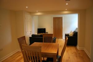 een woonkamer met een tafel en een bank bij Highlands Apartment 5 in Shanklin
