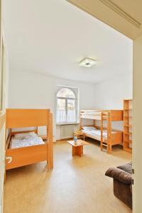 a room with three bunk beds and a couch at Jugendhaus St. Kilian in Miltenberg