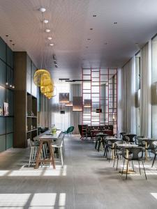 - une salle à manger avec des tables, des chaises et des fenêtres dans l'établissement Okko Hotels Strasbourg Centre, à Strasbourg