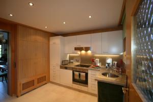 a kitchen with white cabinets and a sink at Ferienwohnung Rengstorf in Oberstdorf