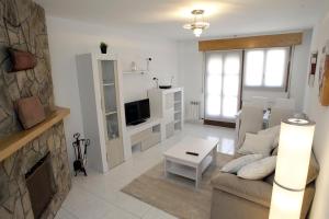 uma sala de estar com um sofá e uma lareira em Apartamento junto al Duero en la Sierra de Urbión em Molinos de Duero