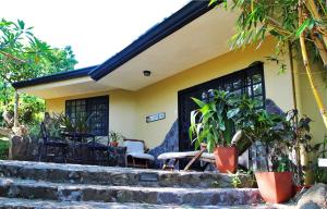 dom z werandą z krzesłami i roślinami w obiekcie Pura Vida Hotel w mieście Alajuela