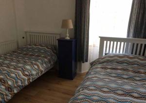 ウェックスフォードにあるFaythe Holiday Home Wexford Townのベッドとテーブルの上にランプが置かれた寝室