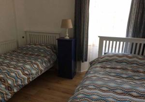 ウェックスフォードにあるFaythe Holiday Home Wexford Townのベッドルーム1室(ベッド1台、テーブルの上にランプ付)