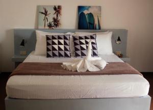 a bedroom with a large bed with pillows at Positano Alona Beach Panglao in Panglao