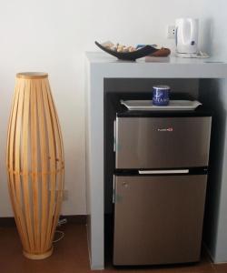 a small refrigerator next to a table with a cup at Positano Alona Beach Panglao in Panglao